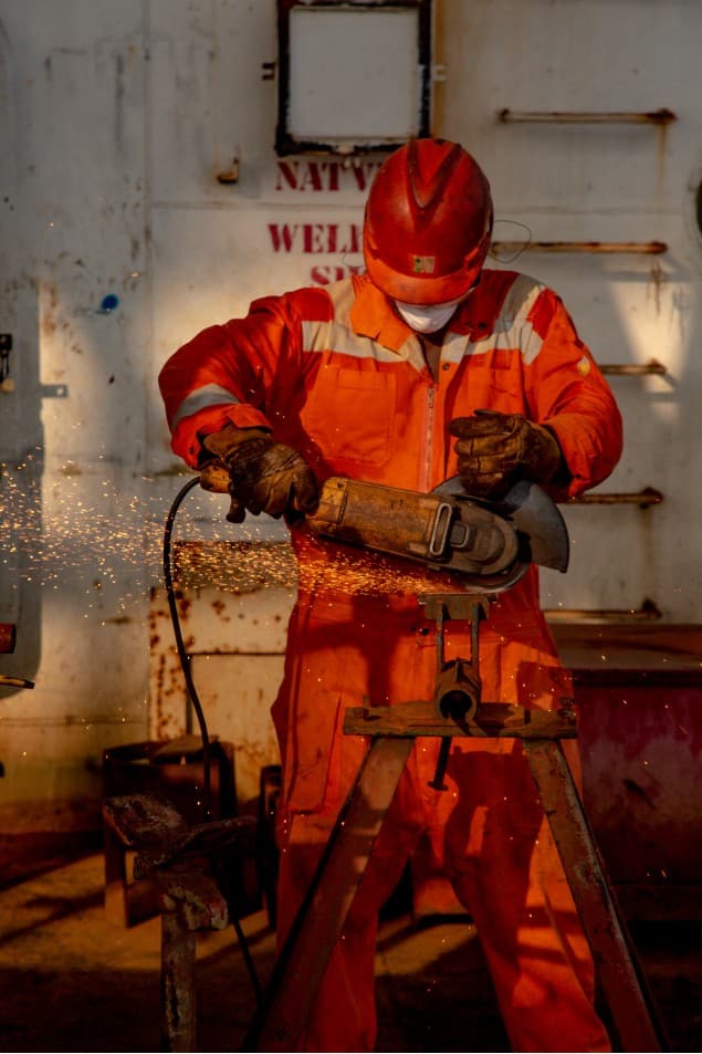Welder grinding metal with sparks flying