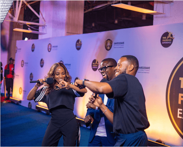 Hosts sharing a joyful moment on the blue carpet