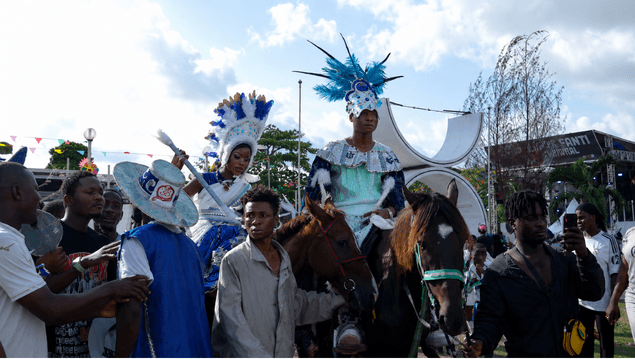Horseback riders in blue and white feathered costumes
