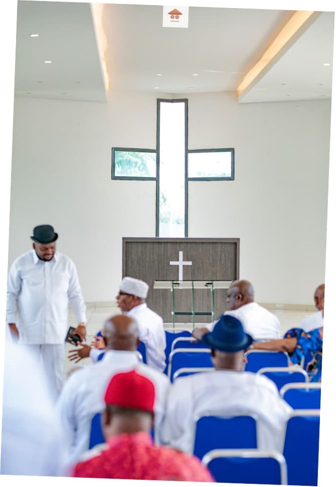 Chapel service beneath a cross-shaped window